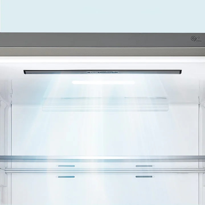 냉장고 내부의 모습입니다. Door Cooling+라는 텍스트가 적혀 있으며, 냉장고 내부에 빛이 비추고 있습니다. 내부는 깔끔하고 현대적인 디자인을 가지고 있습니다.