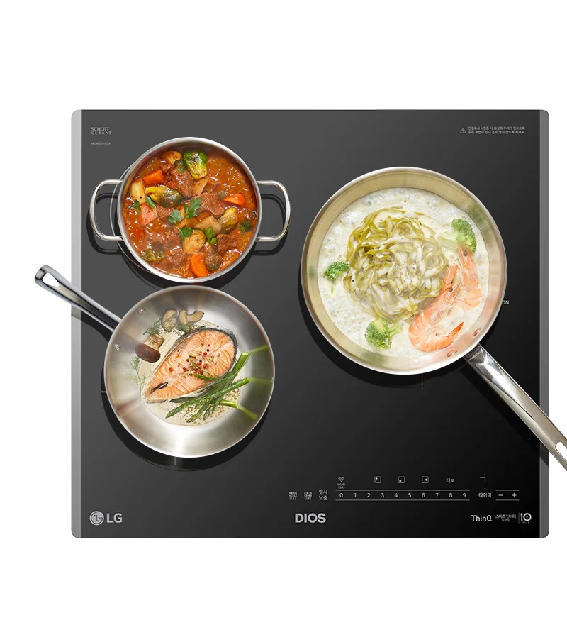 인덕션 레인지 위에 세 개의 냄비와 팬이 놓여 있습니다. 스테인리스 냄비에는 토마토와 채소가 들어간 스튜가 담겨 있고, 스테인리스 팬에는 연어와 허브가 놓여 있습니다. 다른 팬에는 새우와 브로콜리가 들어간 크림 파스타가 조리되고 있습니다. 인덕션 레인지의 조작 패널에는 다양한 설정 버튼이 보입니다.