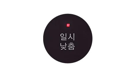 검은색 원 안에 일시 낮춤이라는 텍스트가 있으며, 그 위에 작은 빨간 불빛이 켜져 있습니다.